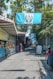 A woman walking down a street next to a store