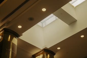 A room with a clock on the wall and a skylight