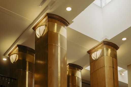A couple of tall gold pillars in a room