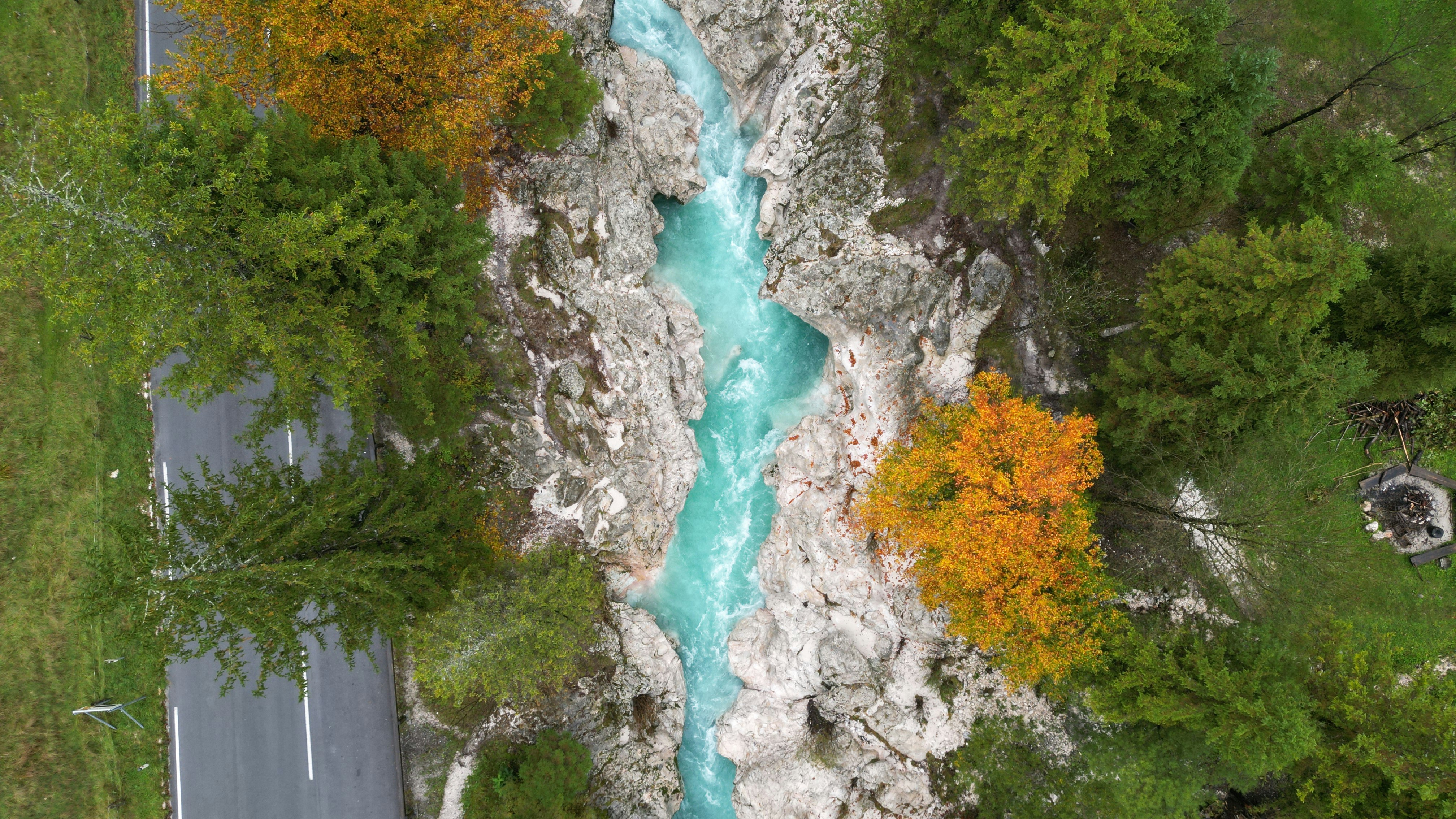 A river running through a lush green forest, Soca river from above