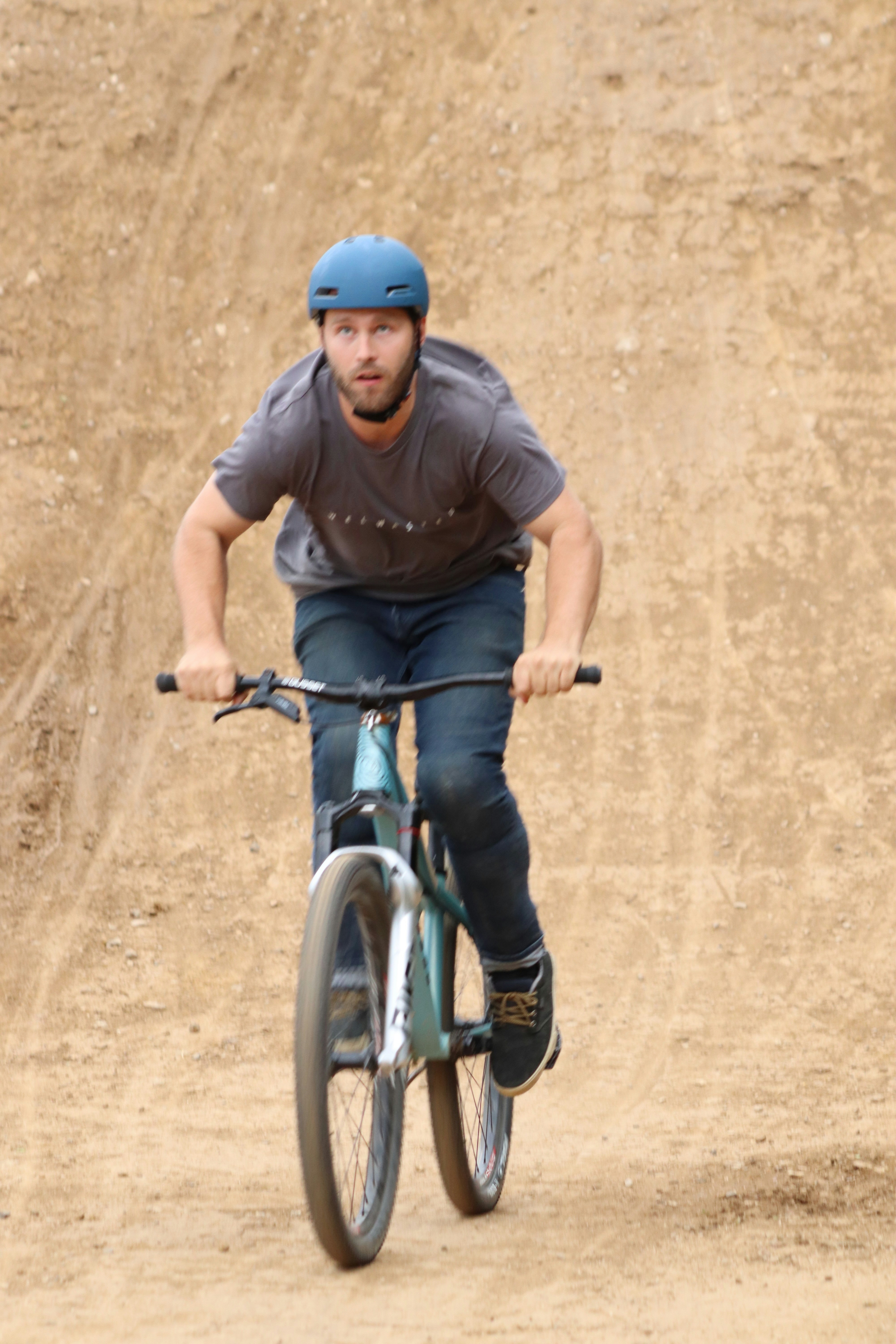 A man riding a bike down a dirt road