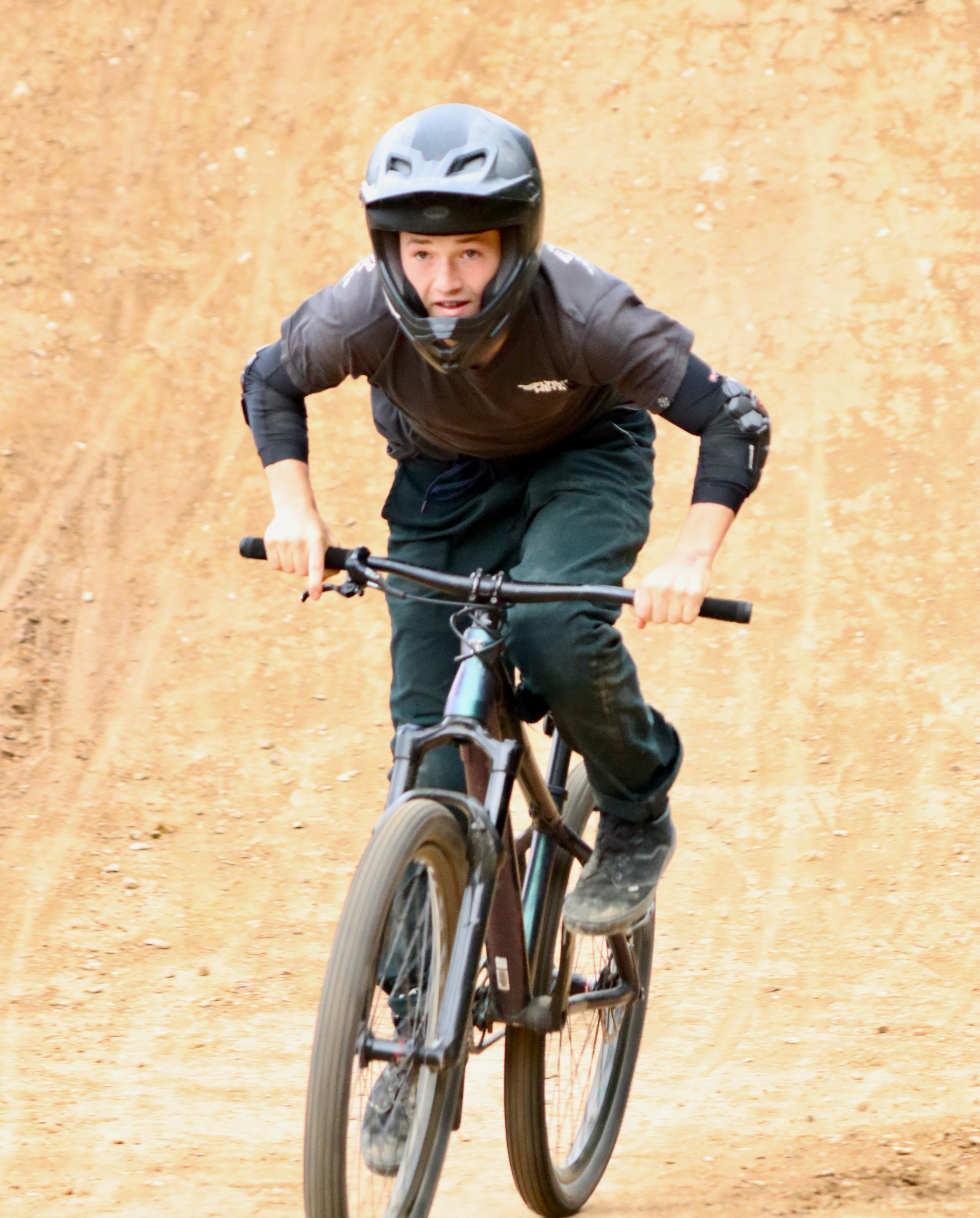 A man riding a bike down a dirt road