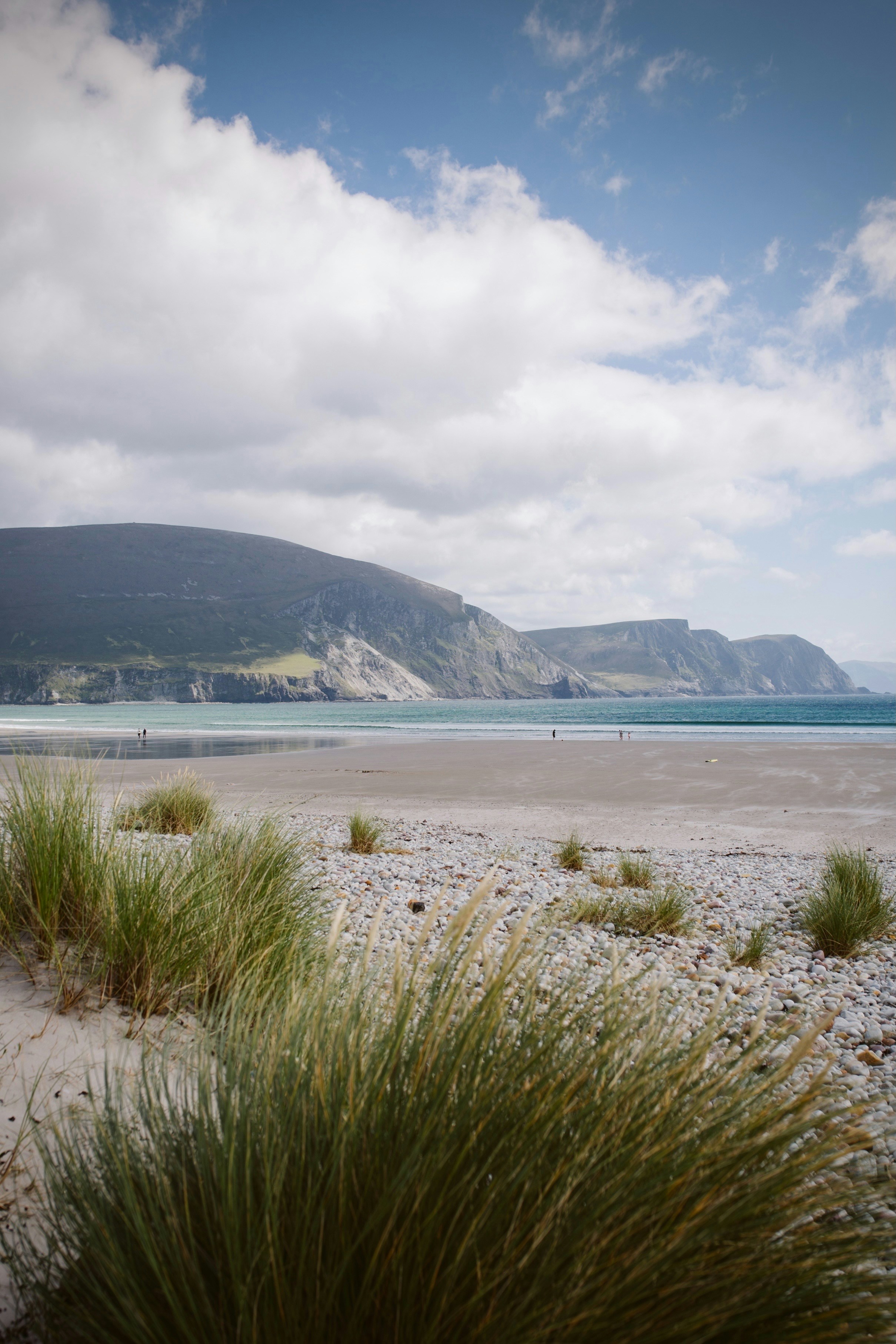 A sandy beach with a mountain in the background