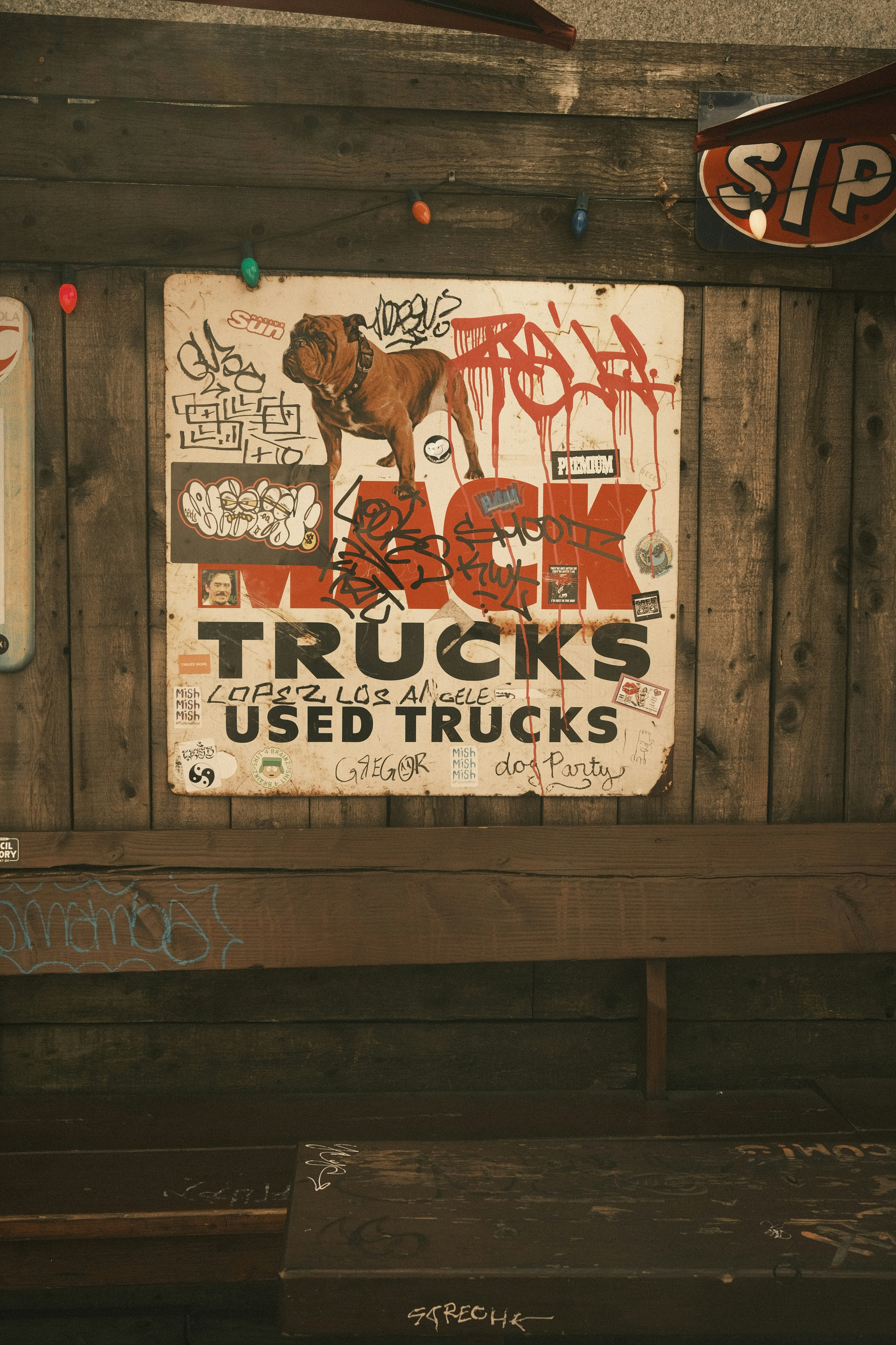 A wooden bench with graffiti on the back of it