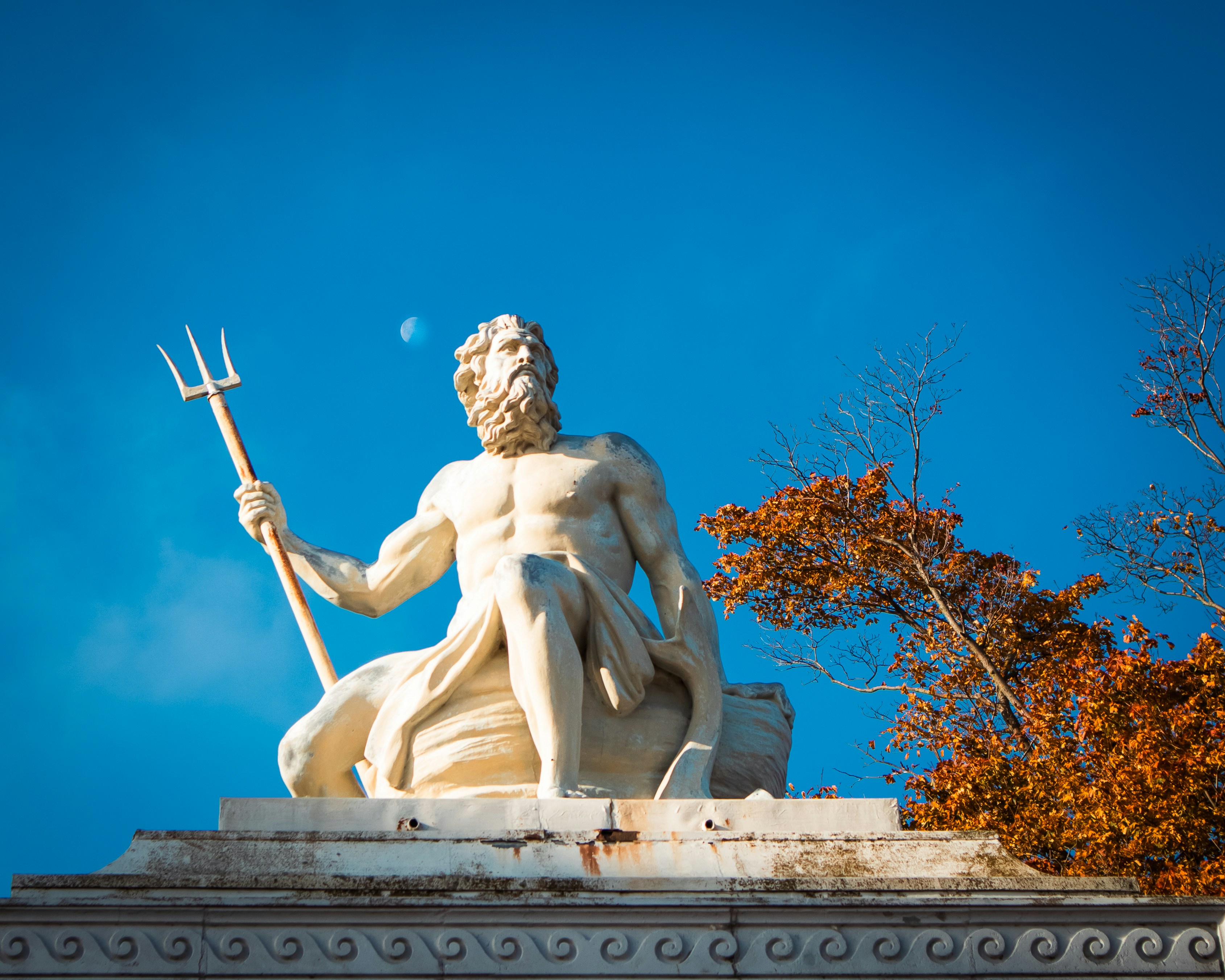 A statue of a man holding a spear on top of a building