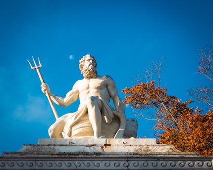 A statue of a man holding a spear on top of a building