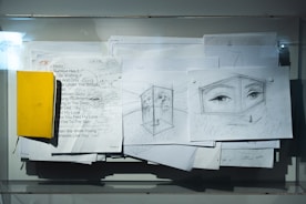 A bunch of papers with a yellow piece of paper on top of it