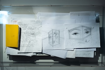 A bunch of papers with a yellow piece of paper on top of it