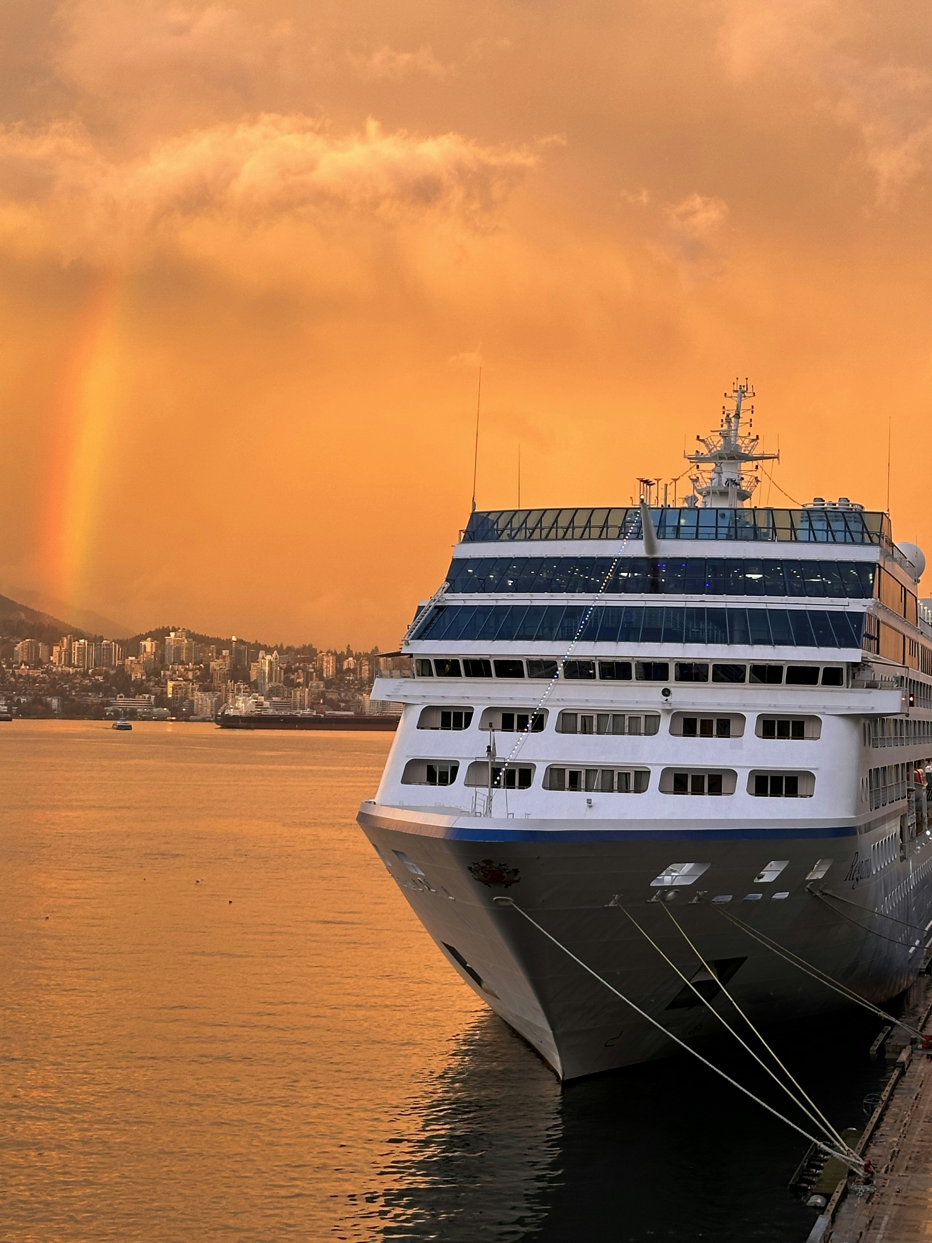 Un crucero atracado en un muelle con un arco iris de fondo