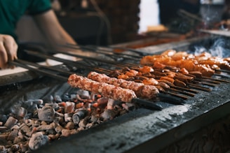 A person cooking food on a grill with tongs