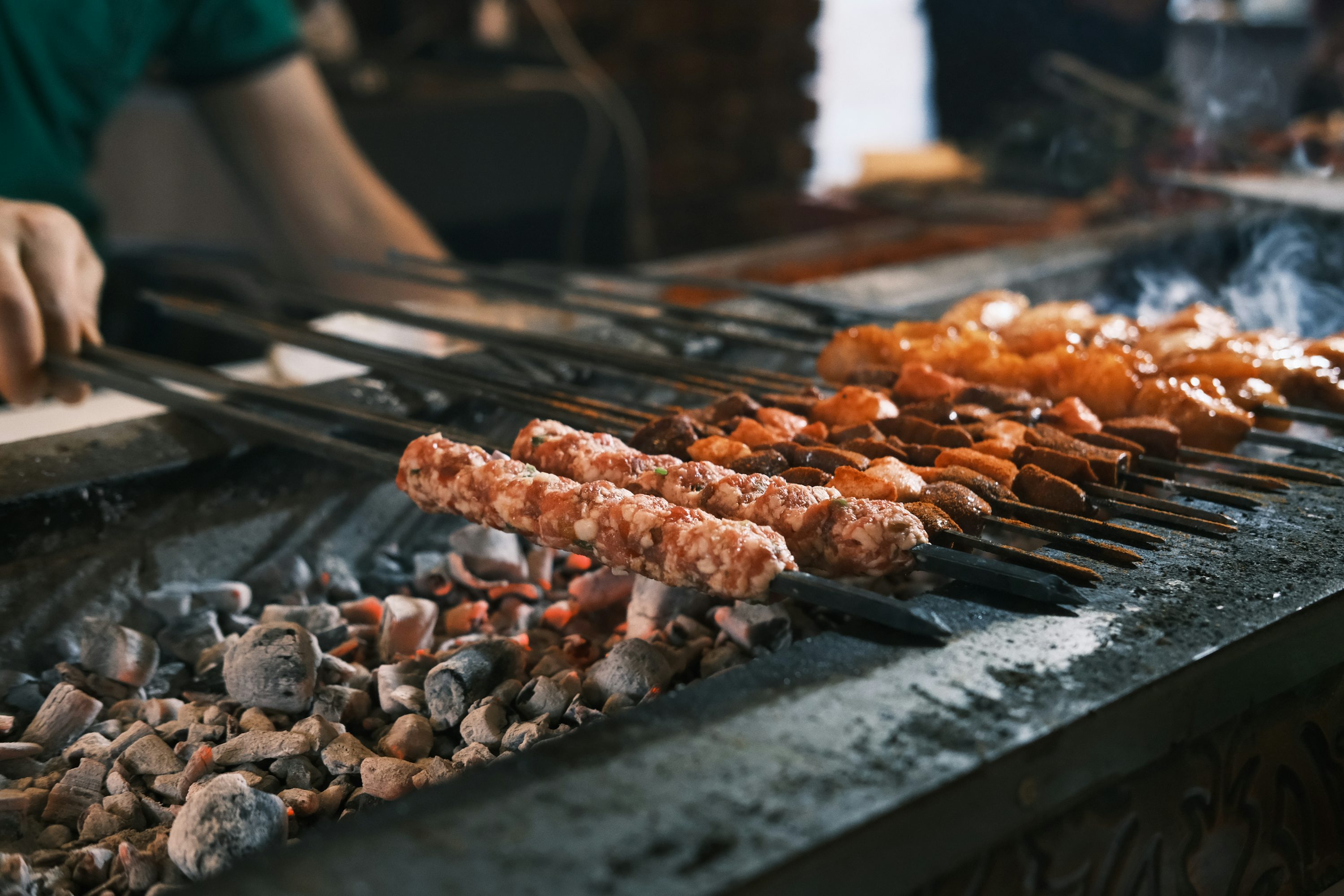 A person cooking food on a grill with tongs