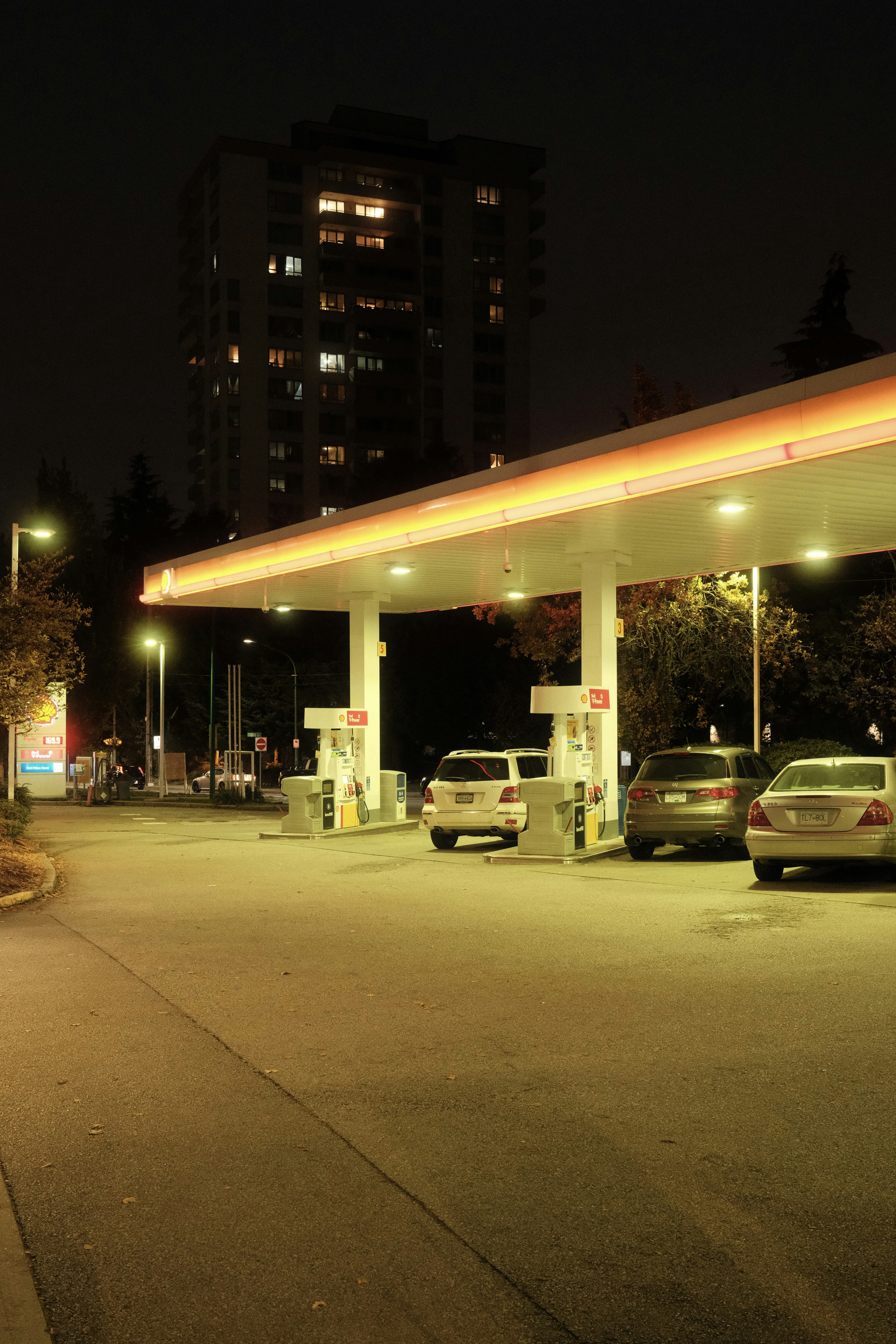 Sebuah pompa bensin di malam hari dengan mobil yang diparkir di tempat