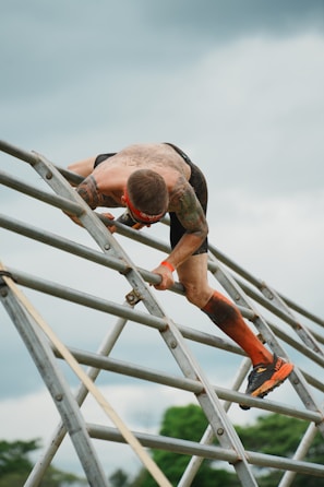 A man climbing up the side of a metal ladder