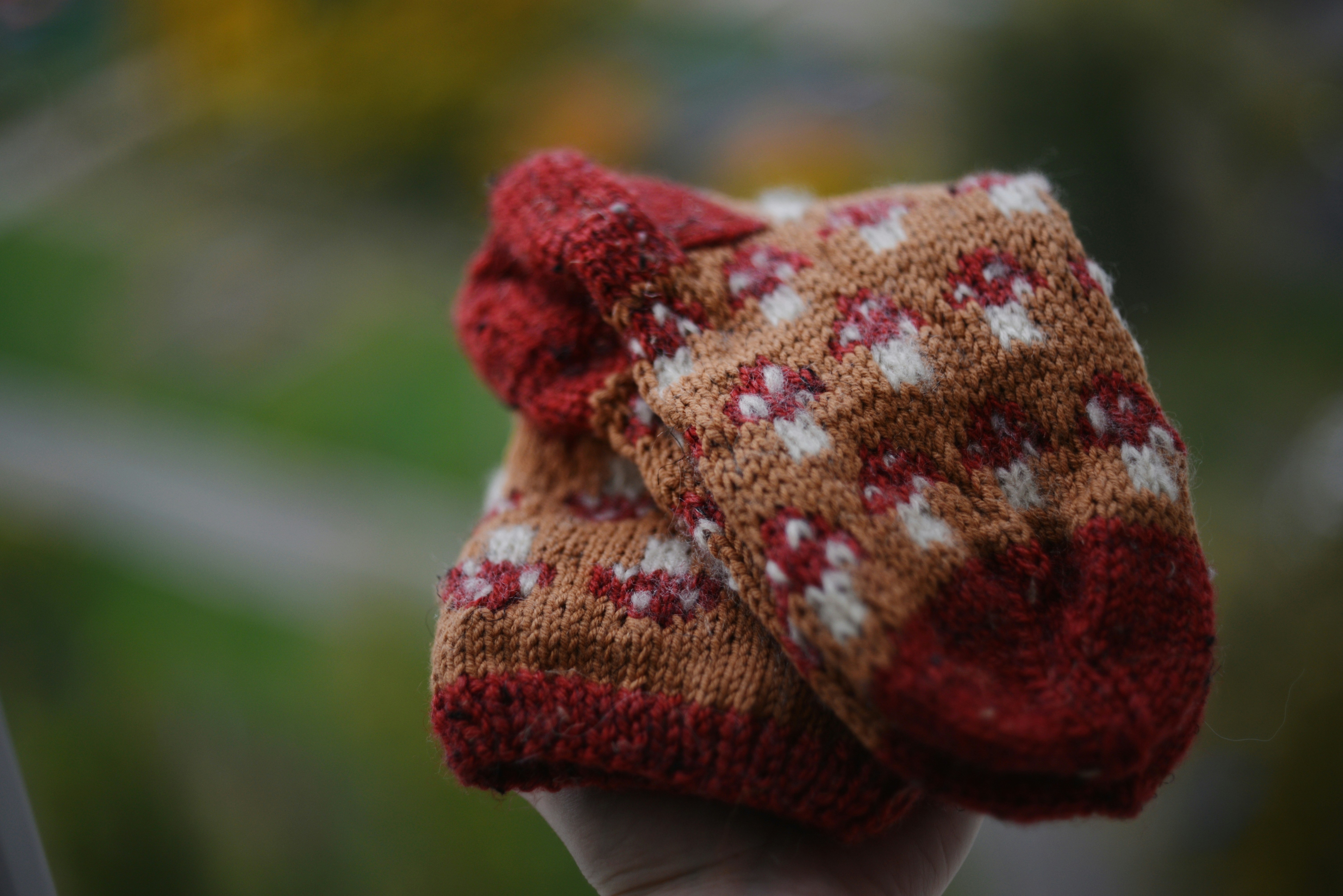 A close up of a person's hand holding a knitted hat
