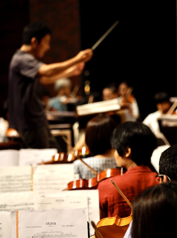 A conductor and orchestra performing in a concert