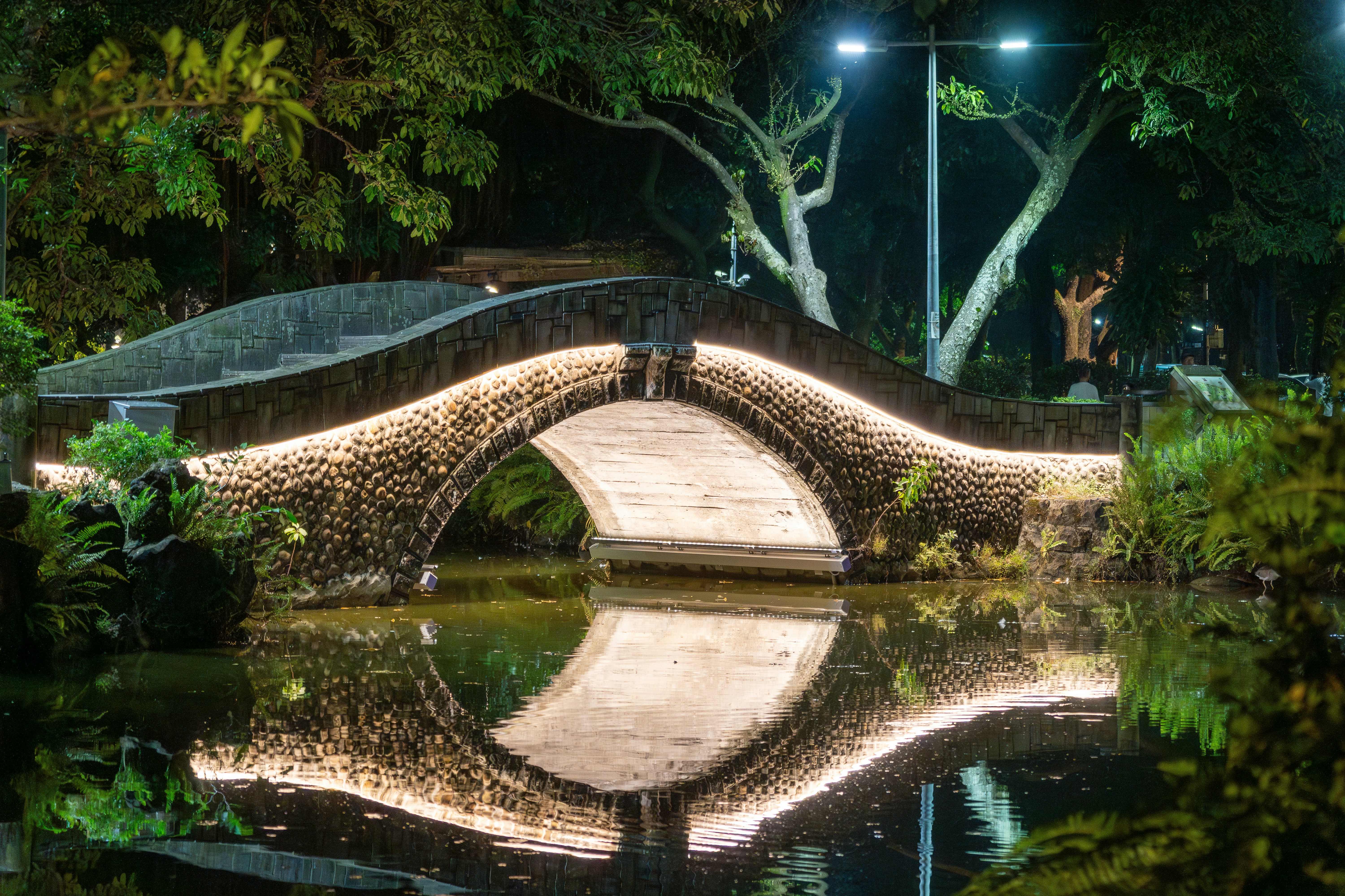 A stone bridge over a body of water at night photo – Free Moon Image on ...