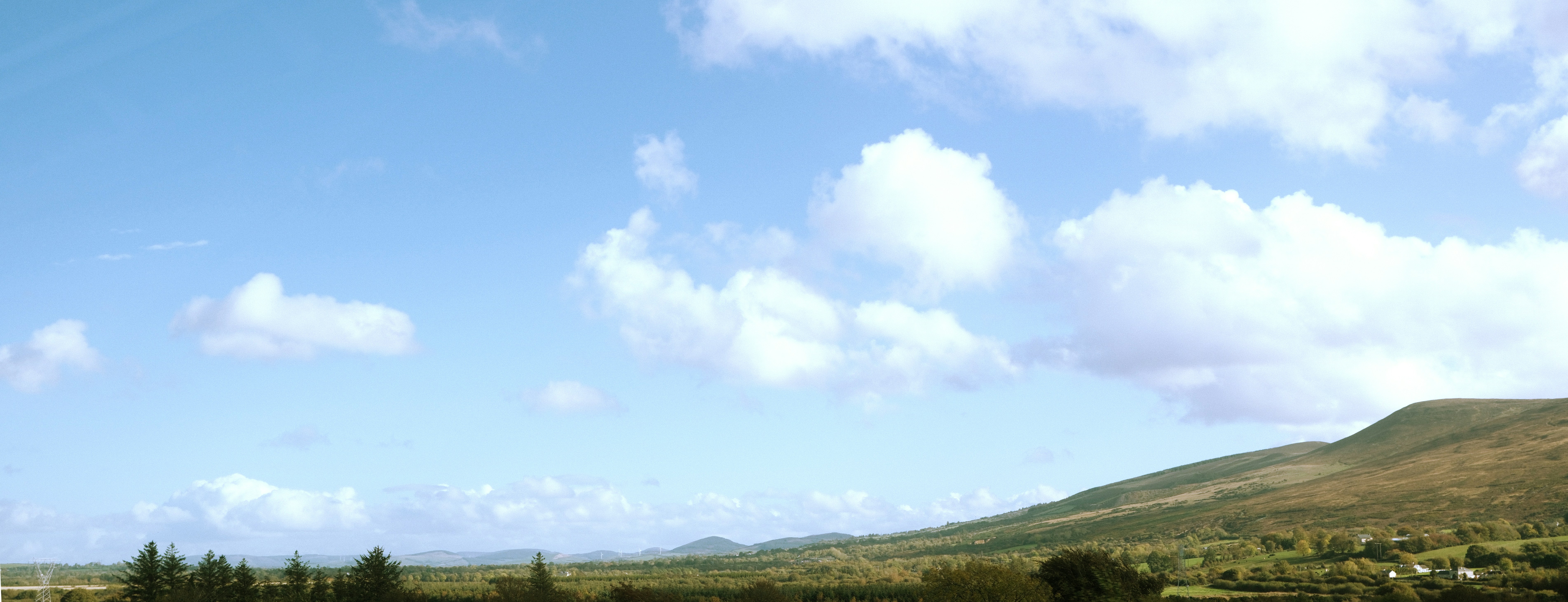A view of a field with a hill in the background