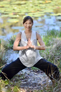 Une femme fait du yoga et médite devant un plan d'eau