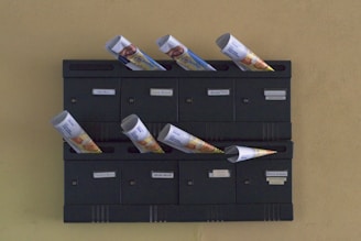 A wall mounted mailbox with a bunch of money sticking out of it