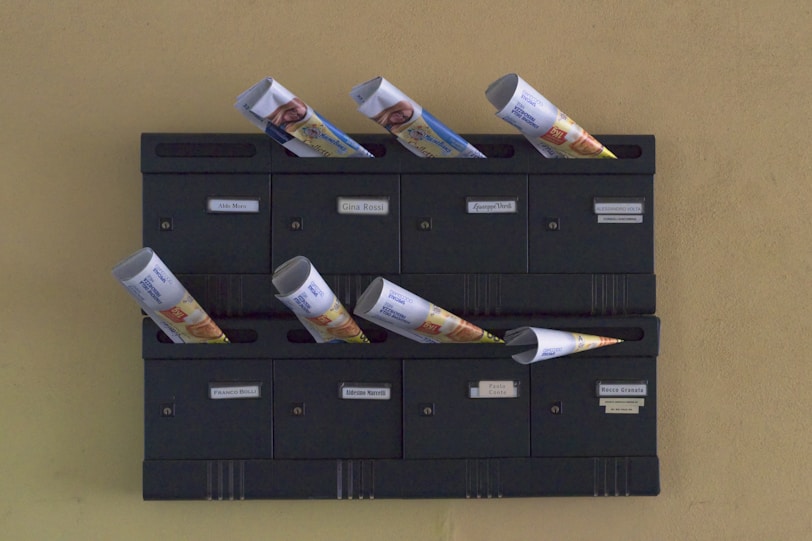 A wall mounted mailbox with a bunch of money sticking out of it