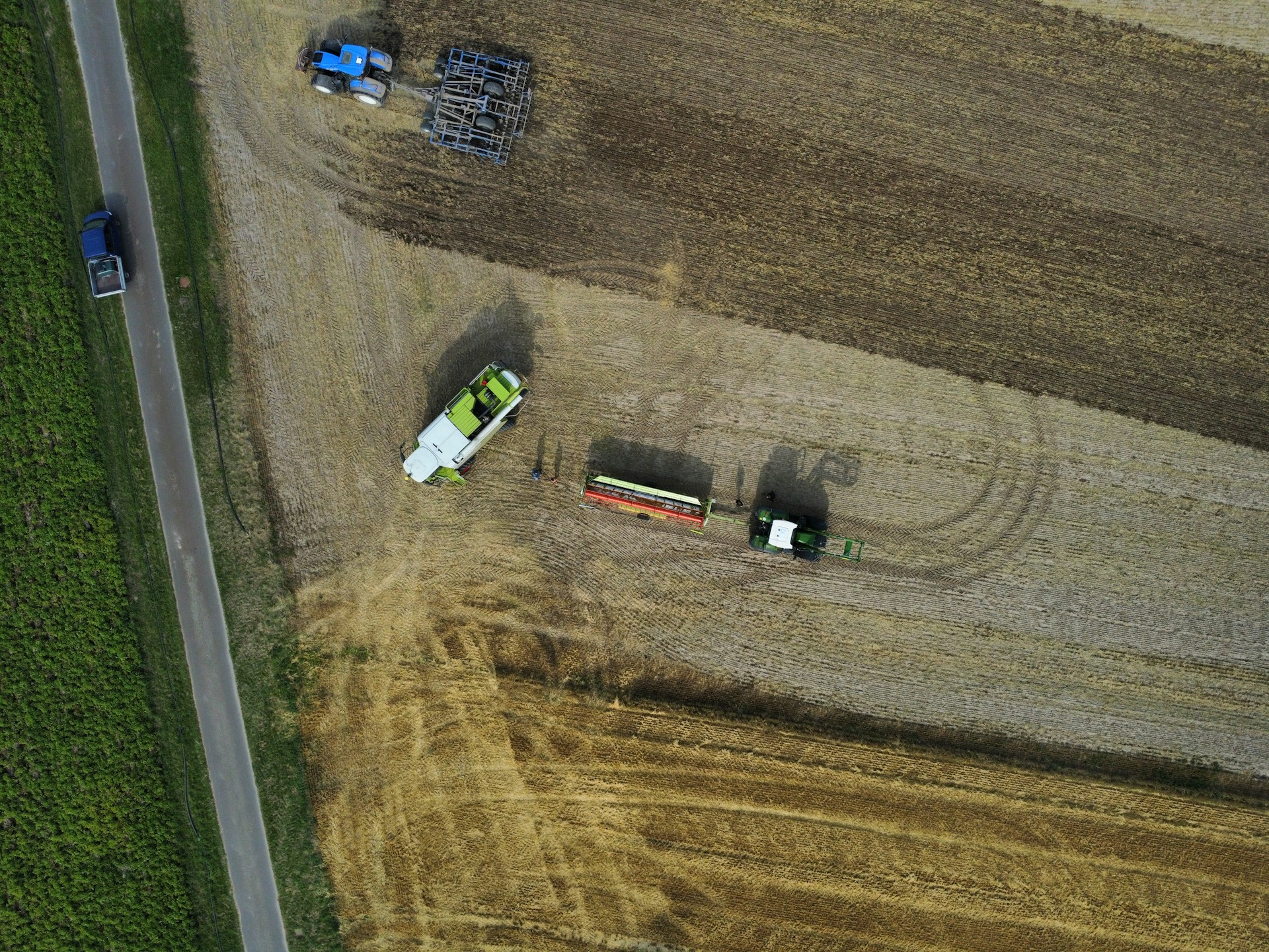 An aerial view of a farm field with two tractors
