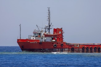 A large red boat in the middle of the ocean