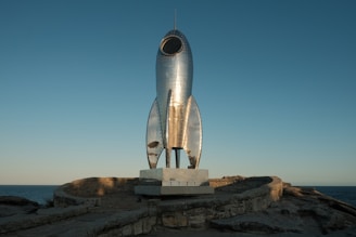 A statue of a rocket sitting on top of a rock
