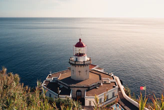 A lighthouse on a cliff overlooking the ocean