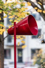 A red mailbox sitting next to a tree