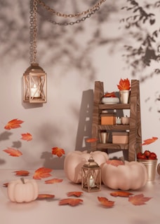 A table topped with lots of pumpkins and candles, fall leaves and lanterns
