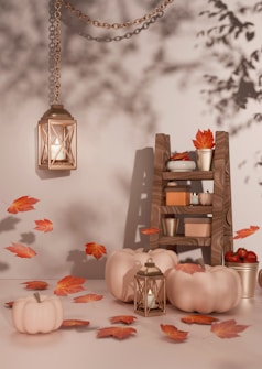 A table topped with lots of pumpkins and candles, fall leaves and lanterns