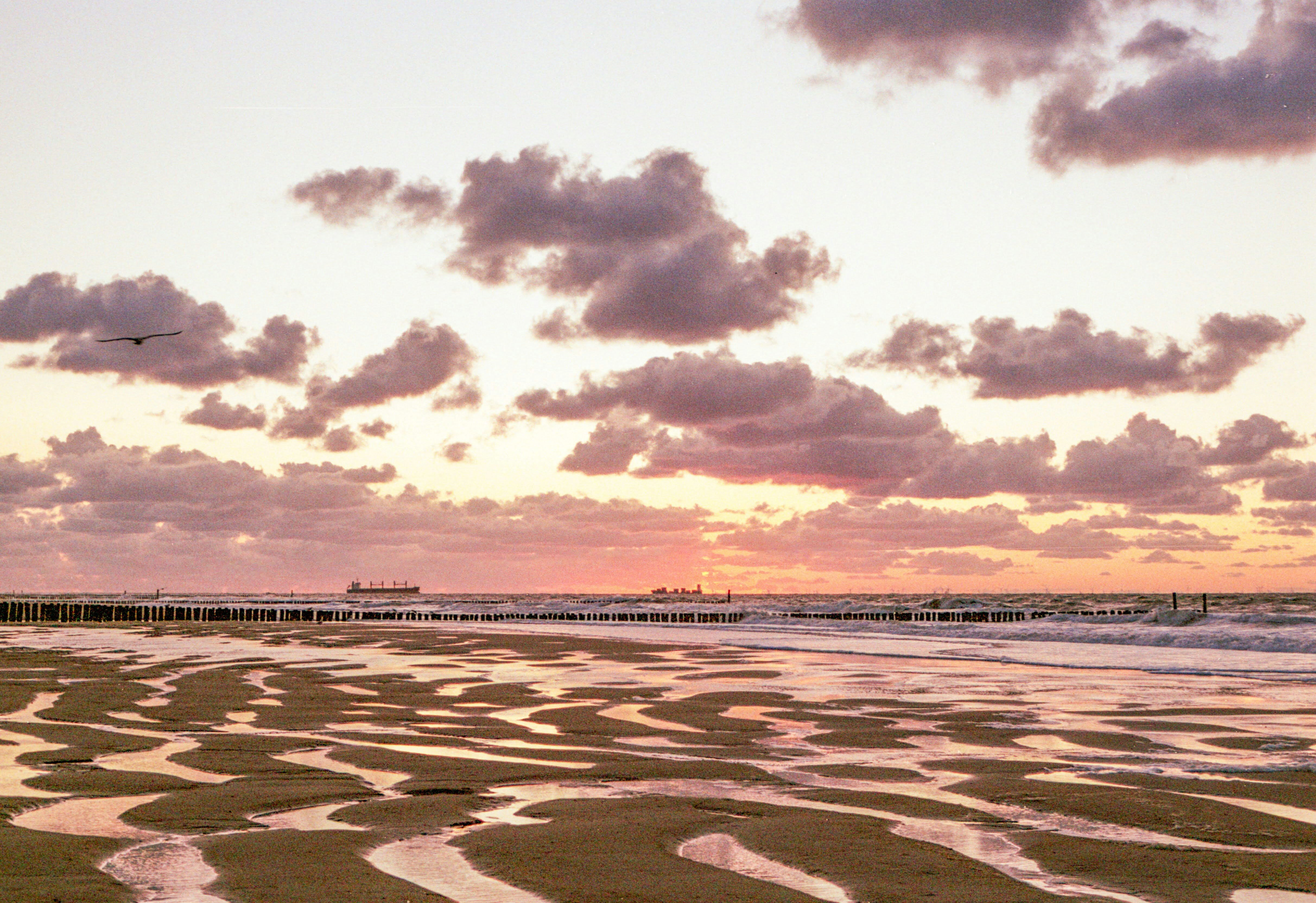 A sandy beach with waves coming in to shore