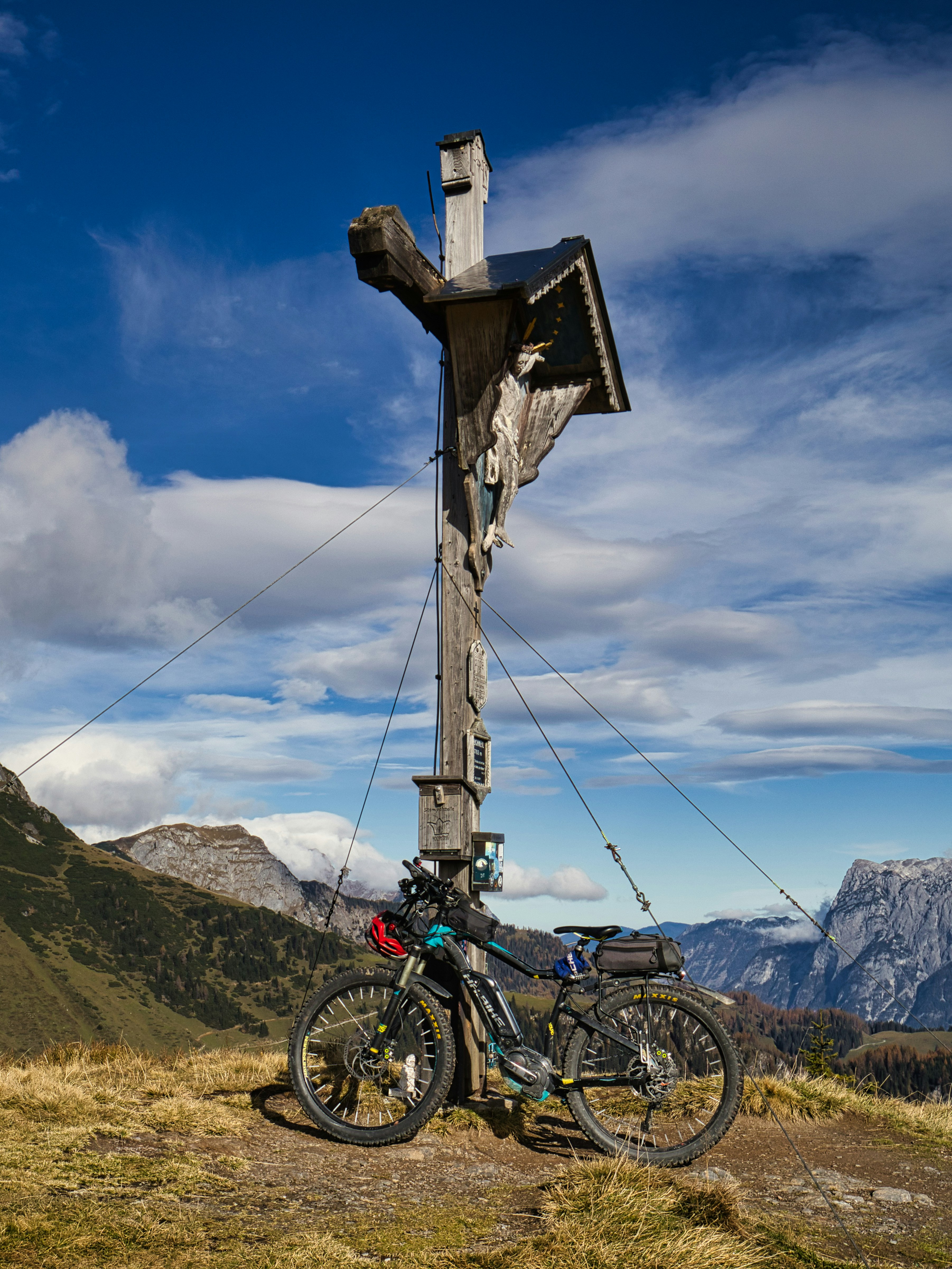 A bike parked next to a wooden cross