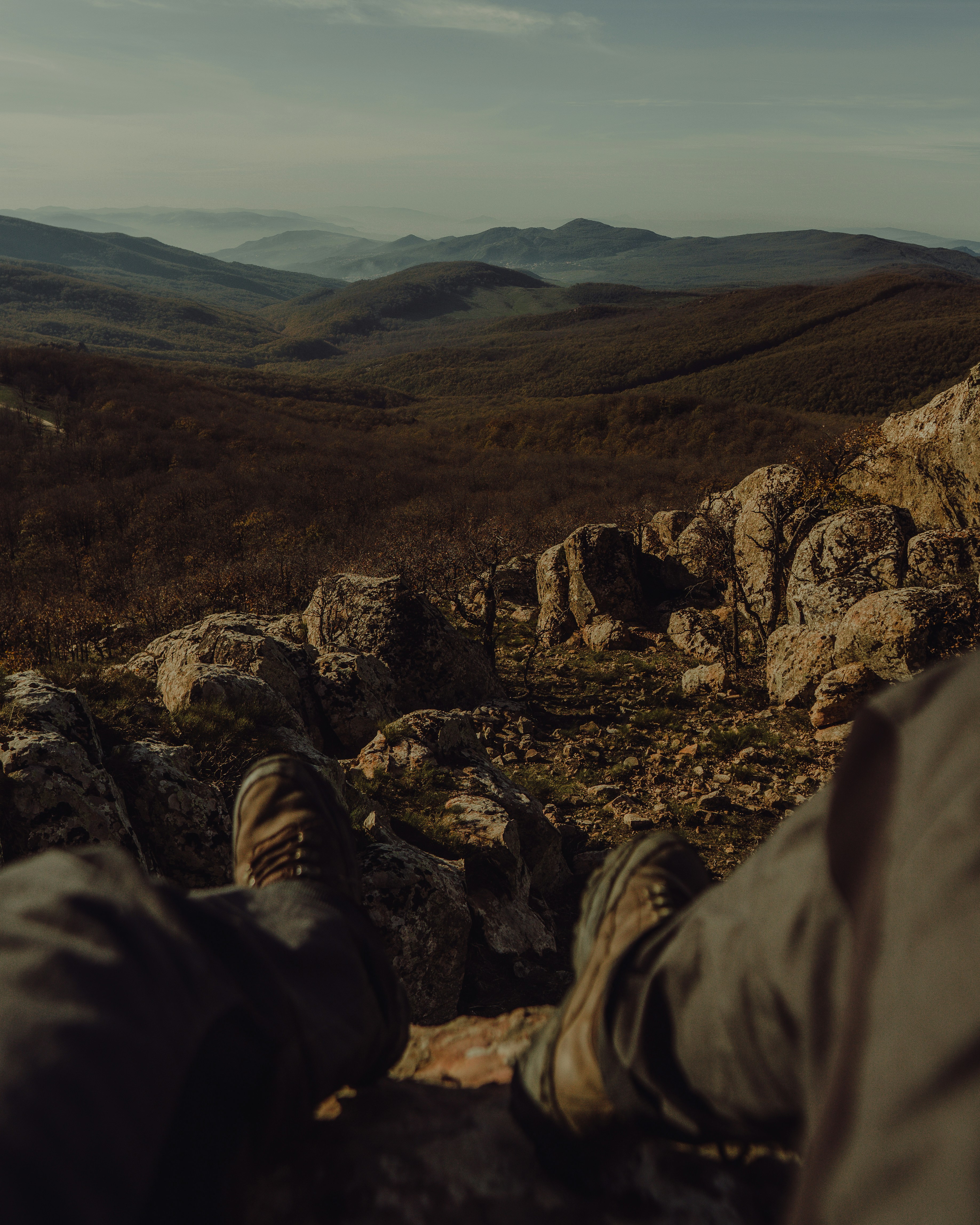 A person laying on a rock with their feet up