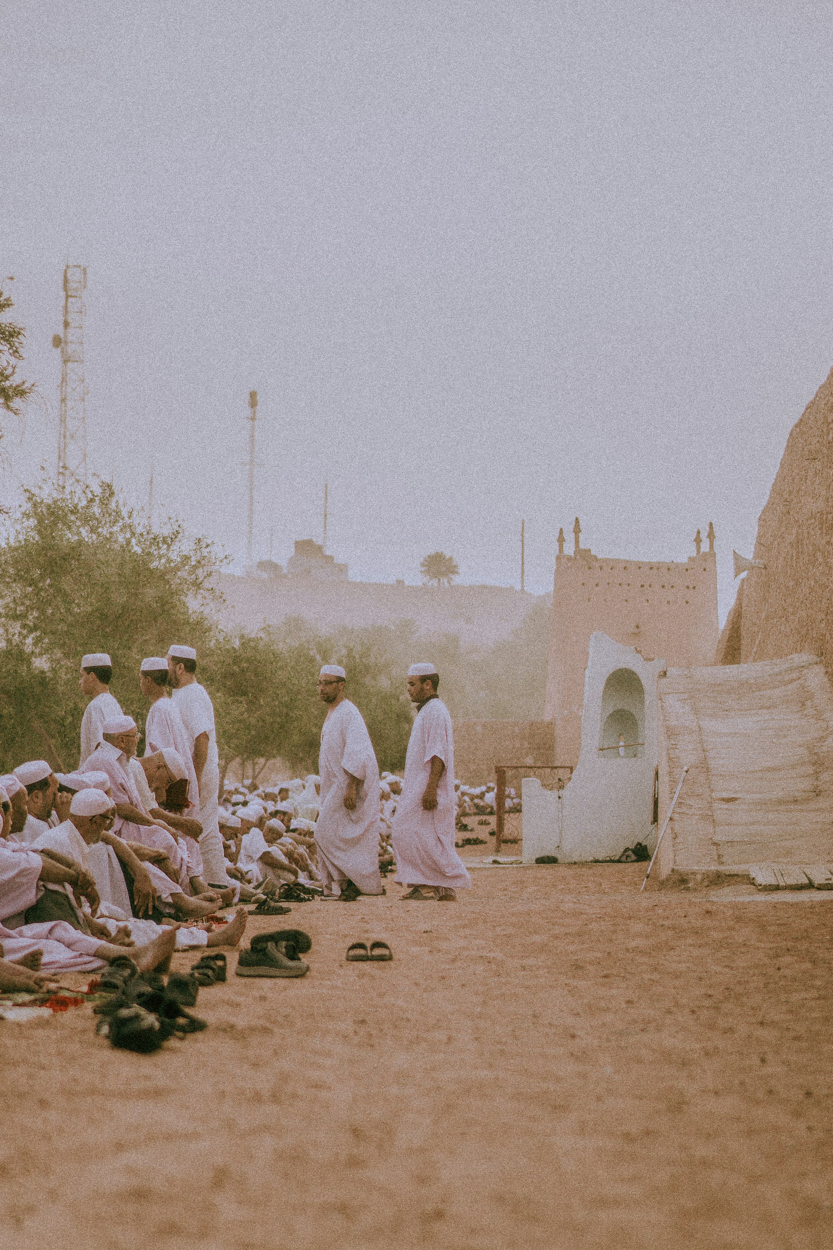 A group of men standing next to each other on a dirt field