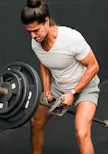 A man holding a barbell while standing in a gym
