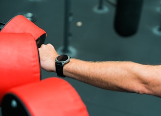 A man holding a red chair in a gym