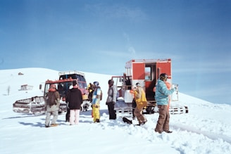 A group of people standing around a truck in the snow