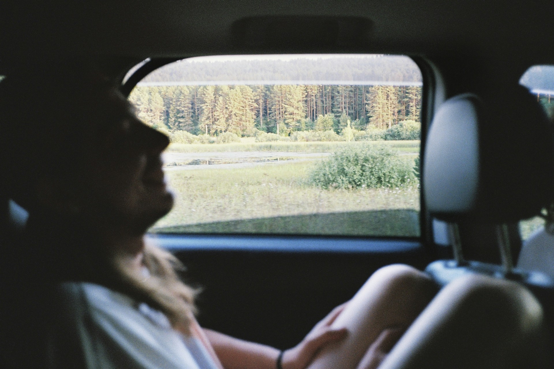 A woman sitting in the back seat of a car