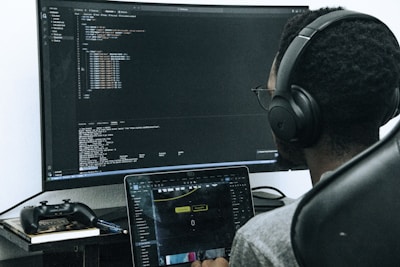 A man sitting in front of a computer wearing headphones