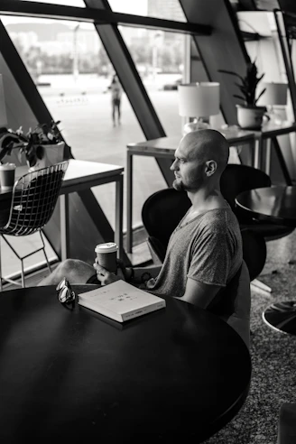 A black and white photo of a man sitting at a table