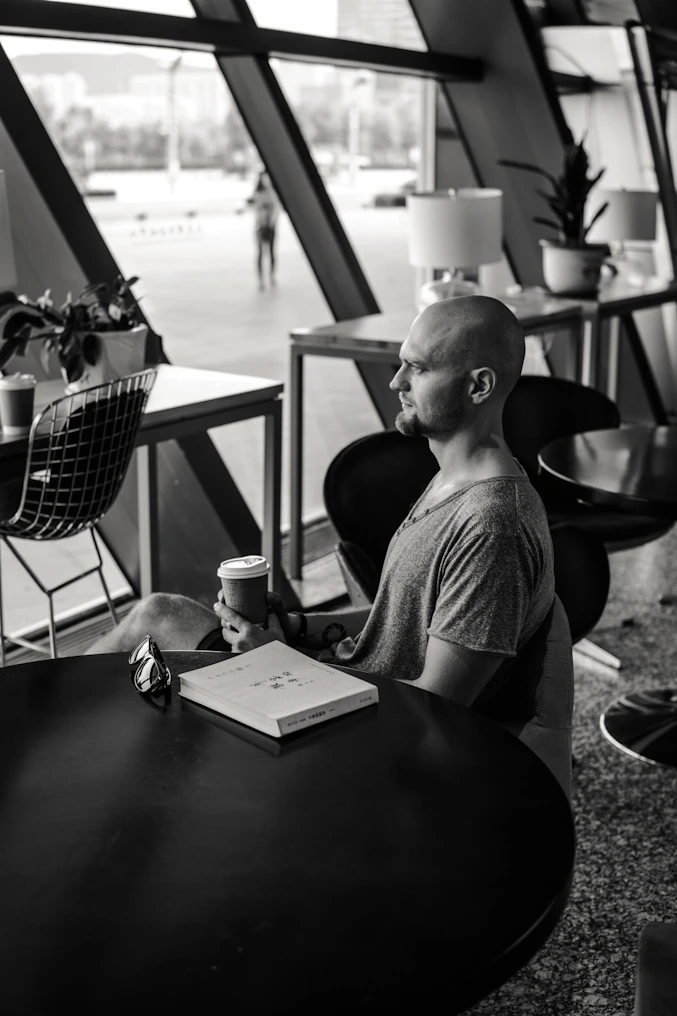 A black and white photo of a man sitting at a table