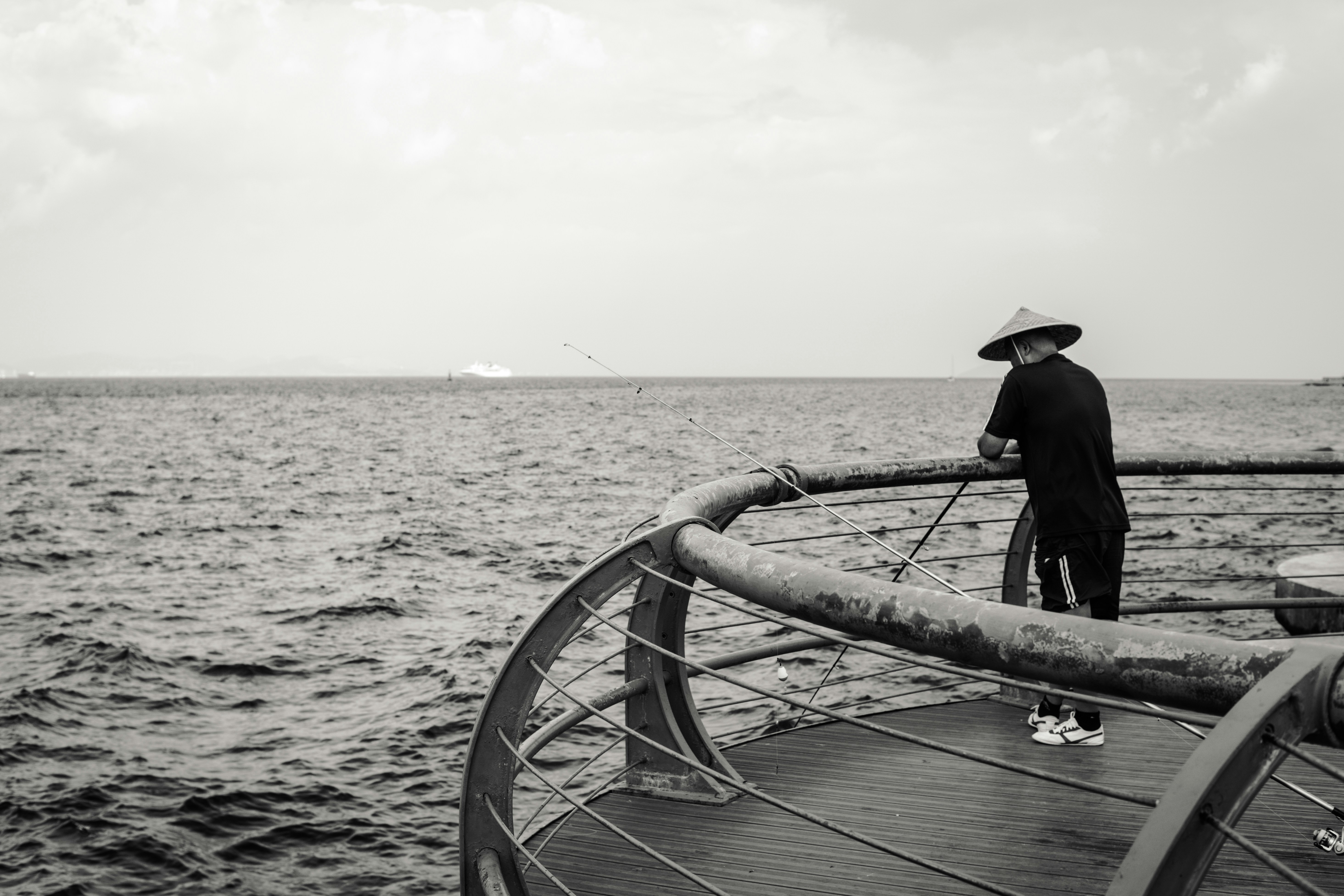 Un hombre de pie en un barco mirando hacia el océano