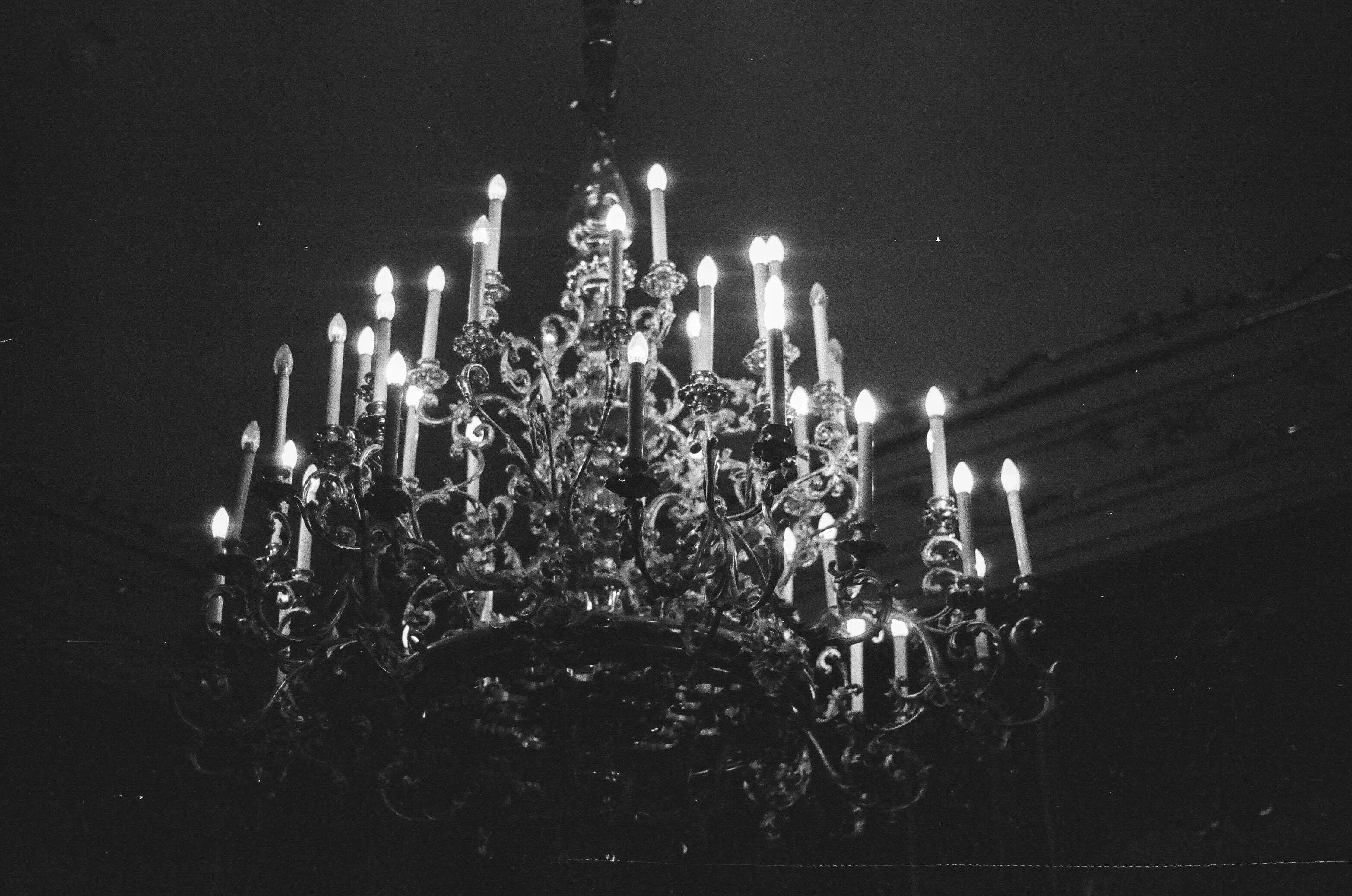 A chandelier with many lit candles hanging from it