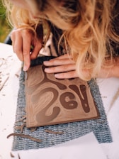 A woman is cutting out a piece of paper with scissors