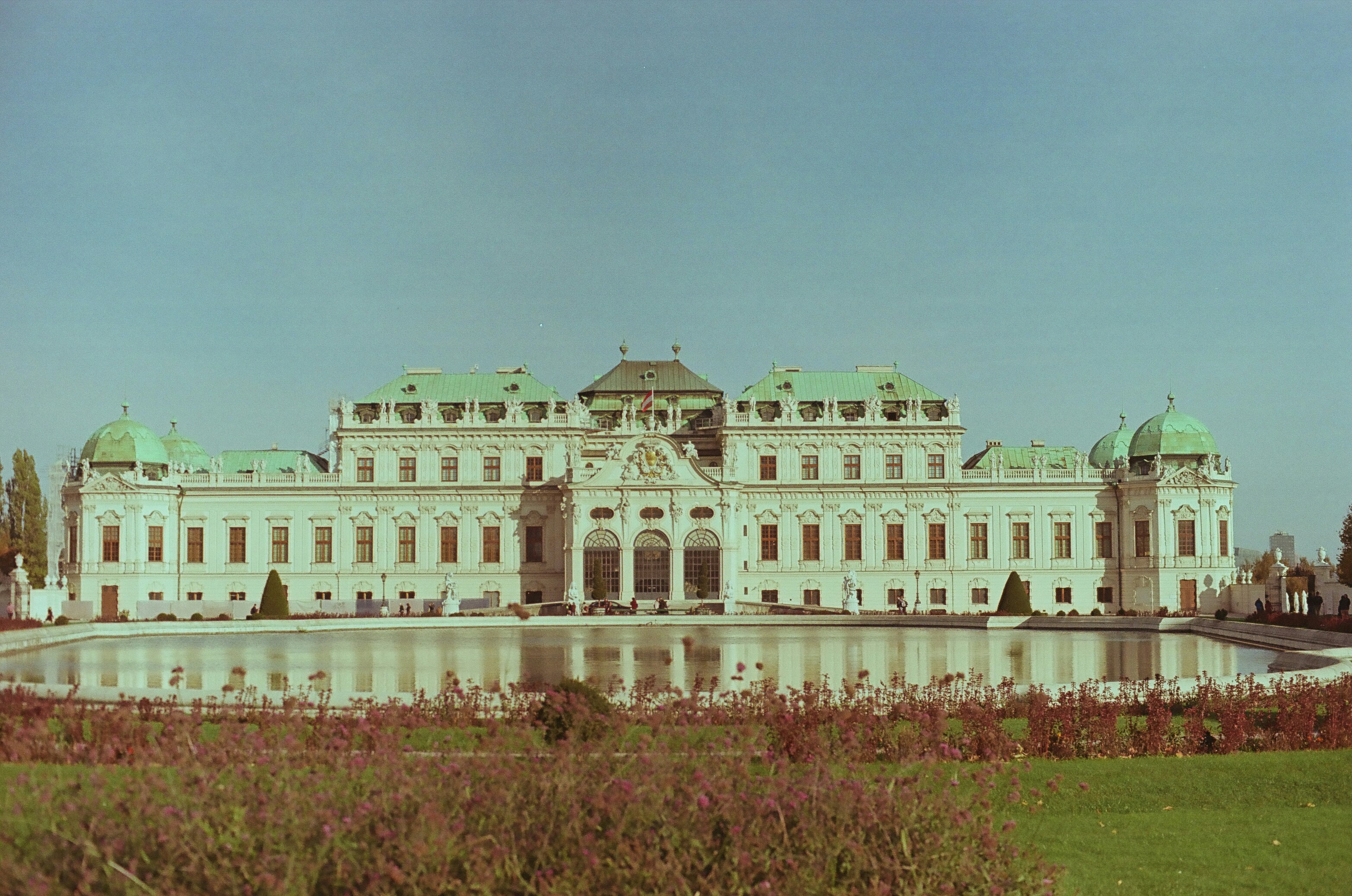 A large white building with a pond in front of it