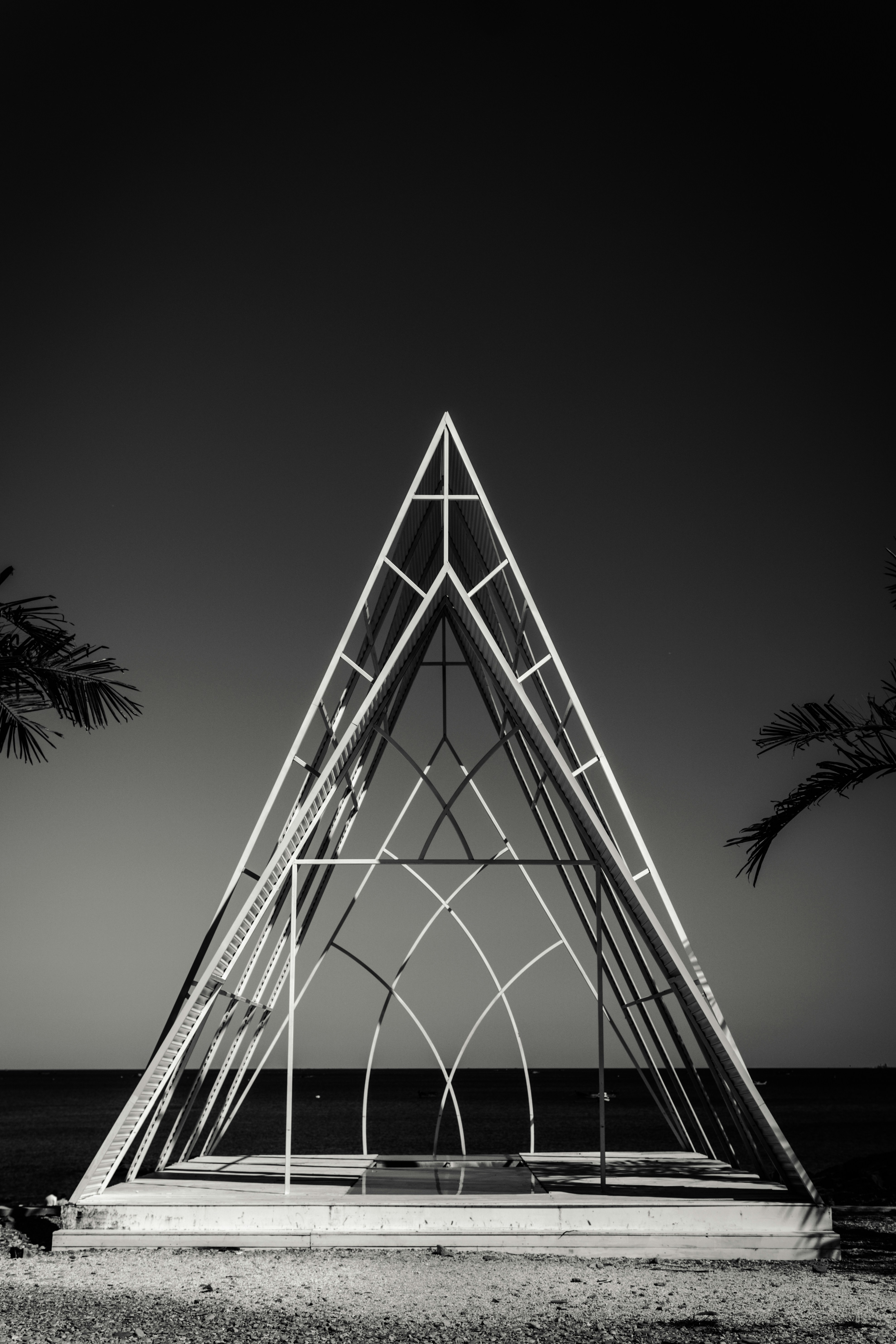 Una foto en blanco y negro de una estructura triangular en la playa