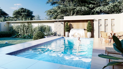 A swimming pool surrounded by a lush green yard