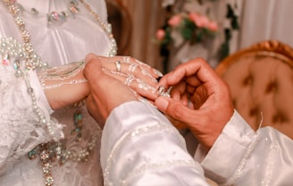 A man and a woman holding hands in front of a bed
