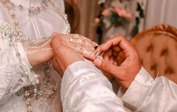A man and a woman holding hands in front of a bed